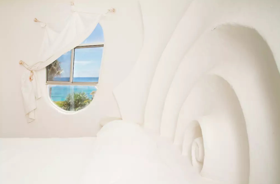 La chambre, avec tête de lit sculptée et vue sur l'océan. Photo: airbnb.com
