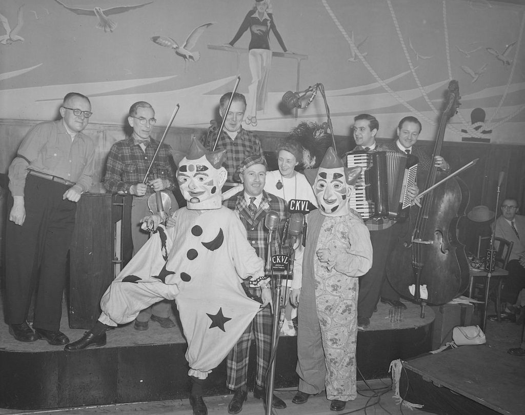 De gauche à droite, Léon Lachance, Oswald, Juliette Béliveau, Claude Séguin et l'orchestre de Adrien Avon sont travestis à la mode des années 1900. Photo: Conrad Poirier. BAnQ